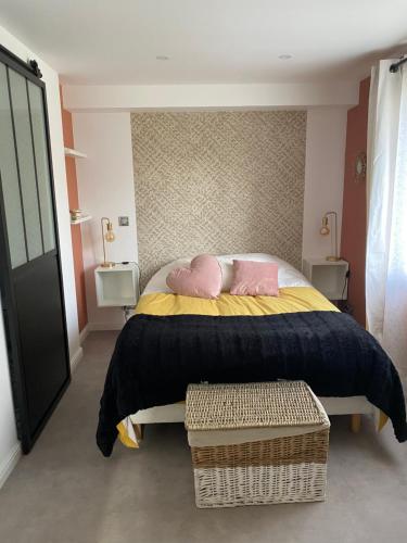 a bedroom with a bed with two pink pillows at Appartement avec espace jacuzzi et terrasse in Rians