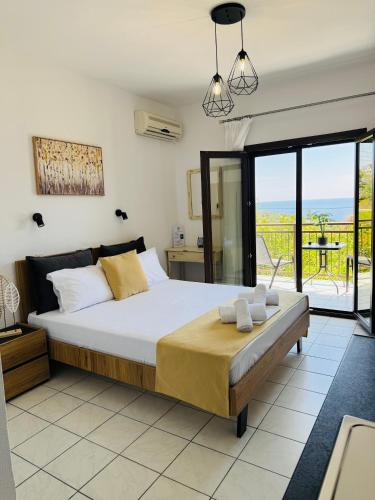 a bedroom with a large bed and a balcony at Faidrahouse in Alyki