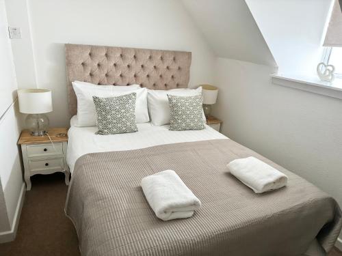 a bedroom with a large bed with two towels on it at City Centre House in Inverness
