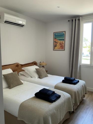 two beds in a hotel room with towels on them at Maison de vacances Helios in Seignosse