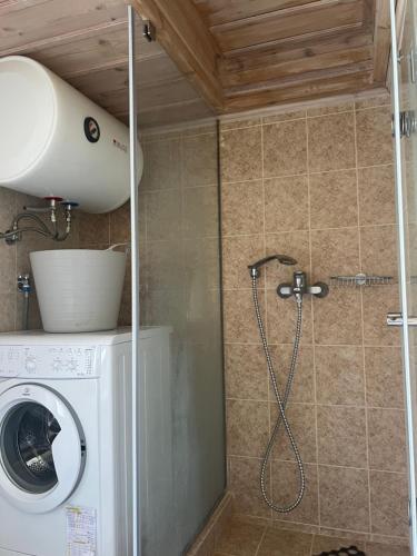 a shower in a bathroom with a washing machine at La Casa Del Cuore in Kiveri