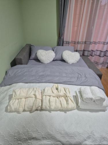 a bed with white blankets and pillows on it at Bella Verde in Vrnjačka Banja