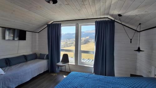 a bedroom with a bed and a large window at Bukhouse Carpathians in Krivorovnya