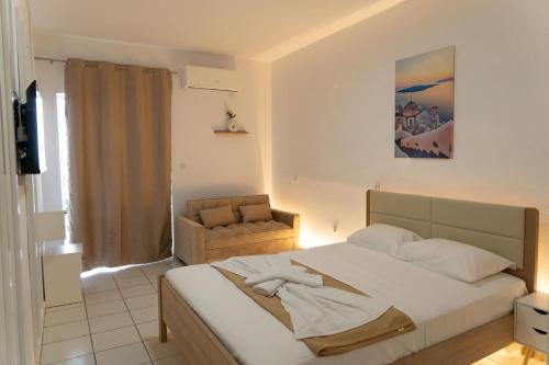 a bedroom with a large bed and a chair at Panagiota Lounge Sea View in Kanali