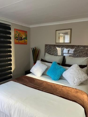 a bedroom with a bed with blue and white pillows at Ecogreen on End in Northam