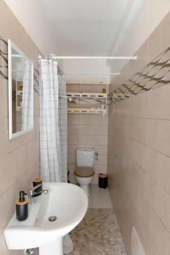 a bathroom with a sink and a toilet at Gosier séjour in Le Gosier