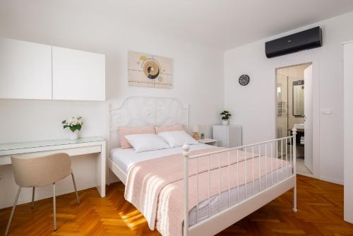 a white bedroom with a bed and a desk at Villa ELENA Room Old Town in Rogoznica