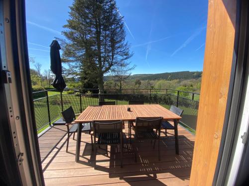 Ein Tisch und Stühle auf einer Terrasse mit Aussicht in der Unterkunft La Roanneuse - Cosy Chalet in Francorchamps
