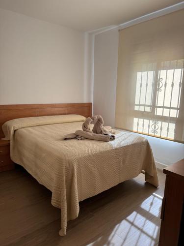 a doll sitting on a bed in a bedroom at Arroyo Alpujarra in Guarros