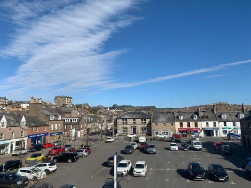 a parking lot with cars parked in a town at The Auld Bakehouse in Stonehaven