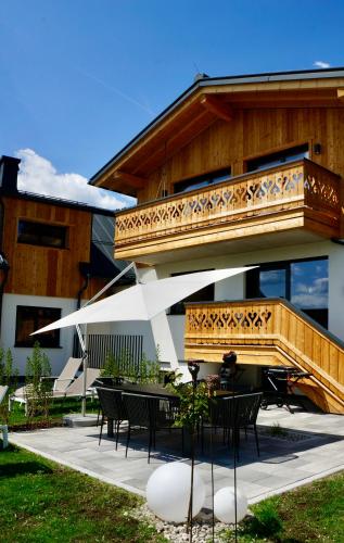 a balcony on a building with tables and chairs at das korda - Ferienhaus & Sommercard in Ramsau am Dachstein