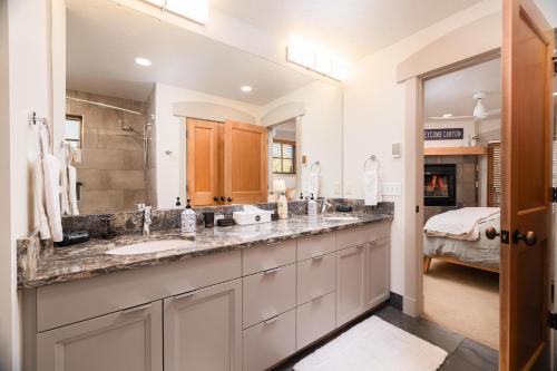 a bathroom with two sinks and a large mirror at First Tracks Townhome in Solitude