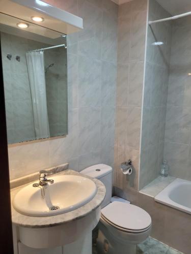 a bathroom with a sink and a toilet and a mirror at ZiRALLA in Allariz