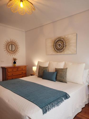 a bedroom with a white bed with a blue blanket at ZiRALLA in Allariz