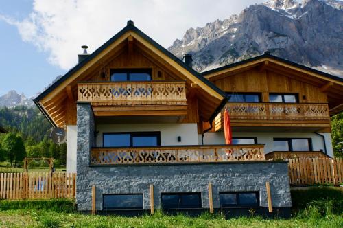a house with a balcony on top of it at das korda - Ferienhaus & Sommercard in Ramsau am Dachstein
