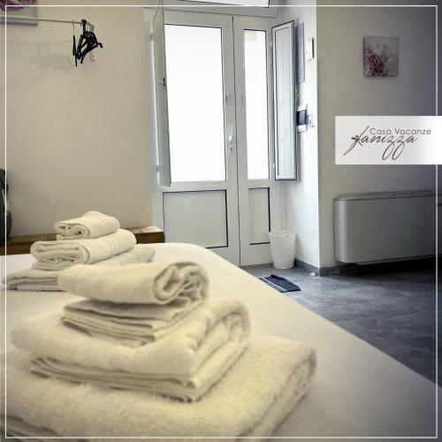 a pile of towels sitting on top of a bed at Rebecca e Sofia Stone House affittacamere in Alberobello