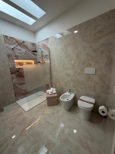 a bathroom with a toilet and a sink and a shower at Lu Sule lu Mare le Luci in Scorrano