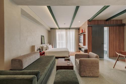 a hotel room with a bed and a couch at Gres Apartments Medellin in Medellín