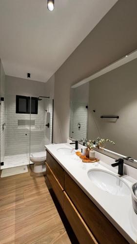 a bathroom with two sinks and a toilet and a mirror at Retreat Boquete Cabins in Bajo Boquete