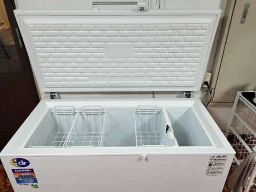 a white dishwasher with three dishes in it at 民宿 とうの浜 in Yasuda