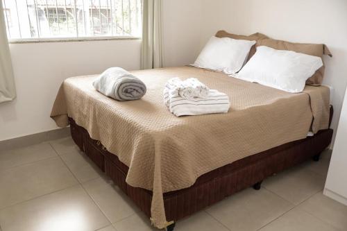 a bed with towels sitting on top of it at Aeroporto e praia Studio Casal in Vitória