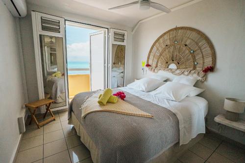 a bedroom with a large bed with a view of the ocean at La Perle Fleur d'Epée in Le Gosier