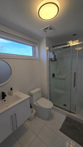 a bathroom with a toilet and a glass shower at Stylish Townhome Gem with Several Amenities Just Minutes To The Falls in Niagara Falls