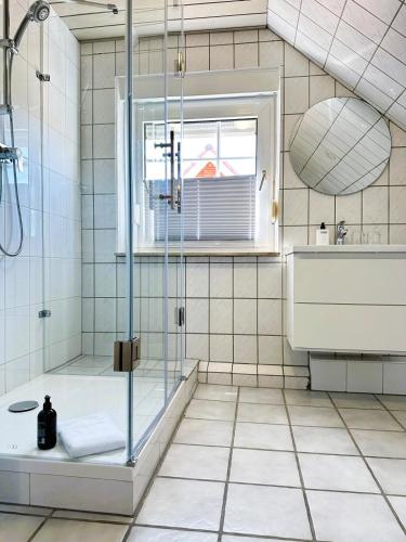 a bathroom with a shower and a tub and a sink at ANKERHUUS Norddeich in Norddeich