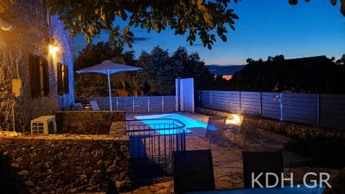 a backyard with a swimming pool at night at Private Villa Demetra 1768 with pool - close to Fiskardo in Fiskardo