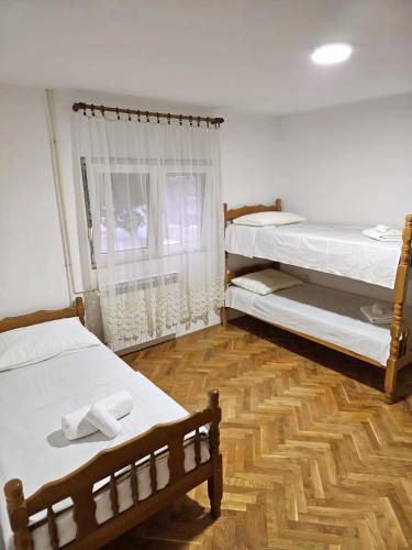 a bedroom with two bunk beds and a wooden floor at Vikendica Tobi in Čapljina