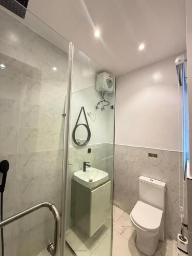 a bathroom with a shower and a toilet and a sink at Starella Apartments in Lekki