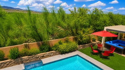 a backyard with a swimming pool and a red umbrella at Lighted Pool Nights Fenced Yard & Mountain View in Tucson
