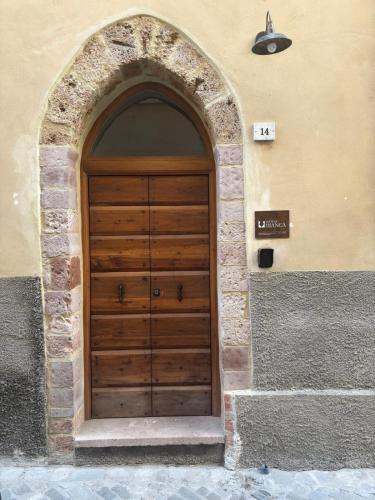 a wooden door in a building with an arch at Suite di Bianca in Foligno