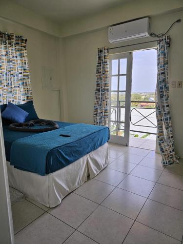 a bedroom with a bed and a door to a balcony at Riseland Breeze Collection in Carnbee Village