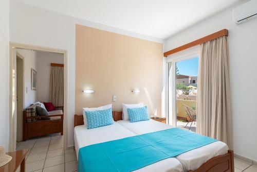 a bedroom with a large bed and a balcony at Rosmaris Apartments in Platanias