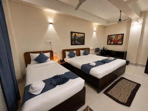 a hotel room with two beds with towels on them at The Happy Nest- A Boutique Stay only 7 mins from Nemcare, Apollo, Physicswalla, Allen in Guwahati