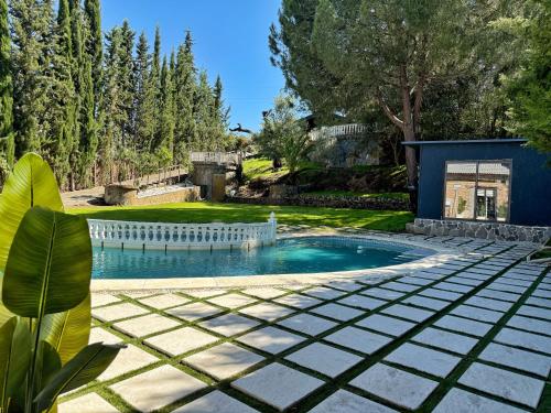 a swimming pool in a yard with trees at Luna House Sevilla in Guillena