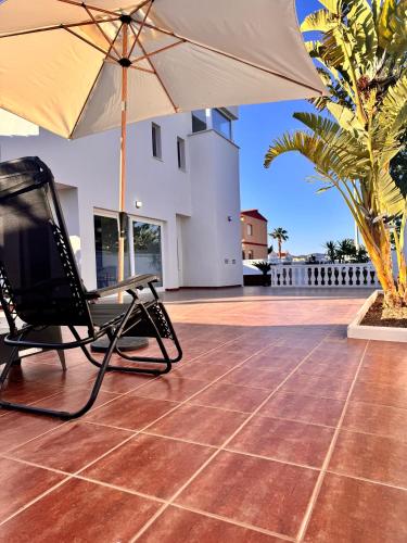 a chair and an umbrella on a patio at Casa Benicasim in Benicàssim