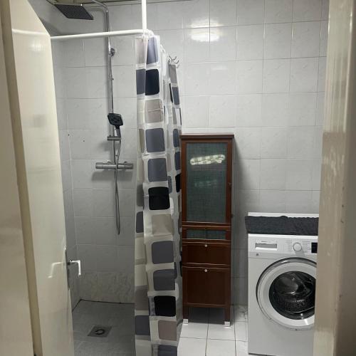 a bathroom with a shower and a washing machine at Gästehaus JaWo in Neuruppersdorf