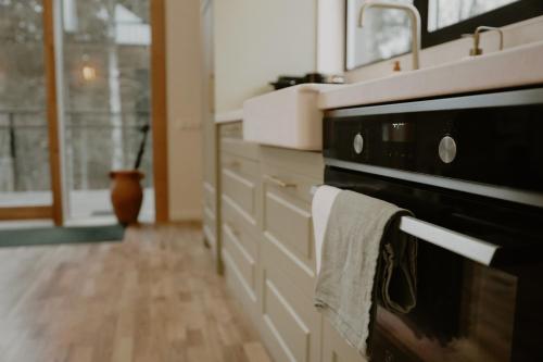 a kitchen with a dish towel hanging from a microwave at Nitaure Glamping in Viļums