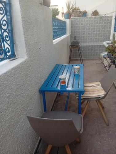 a blue table and a chair on a patio at Summer House in Dar Salah Bey