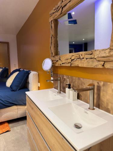 a bathroom with a sink and a mirror at Les Nuits Douces in Bitche