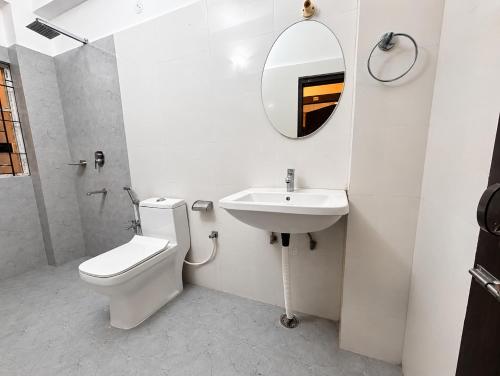 a bathroom with a toilet and a sink and a mirror at The Happy Nest- A Boutique Stay only 7 mins from Nemcare, Apollo, Physicswalla, Allen in Guwahati