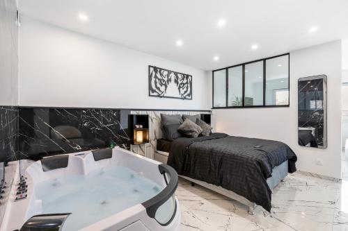a bedroom with a bed and a bath tub at Blāck diamond spa in Mulhouse