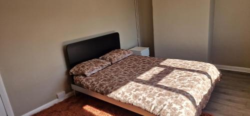 a bedroom with a bed with a comforter on it at 4 Boteler Avenue,Bewsey in Warrington
