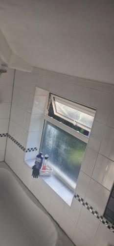 a window in a bathroom with a sink and a tub at 4 Boteler Avenue,Bewsey in Warrington