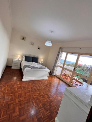 a bedroom with a bed and a large window at Madeira Ocean View in Funchal