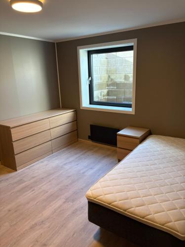 a bedroom with a bed and a window at Wergelandsvegen 40B in Stjoerdal