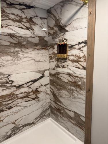 a bathroom with a marble shower with a chandelier at Raystown Country Lodge in Huntingdon