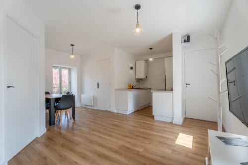 a living room with a table and a kitchen at Le Saphir By Clem in Pélussin